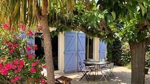 A patio with a table and chairs, surrounded by trees and a blue gate. - Charming 3 bedrooms cottage with a pool  for a typical experience in Provence (Saint-Rémy-de-Provence)