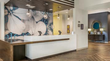 Una recepción con diseño moderno, un mural floral grande y un piso de madera pulida.