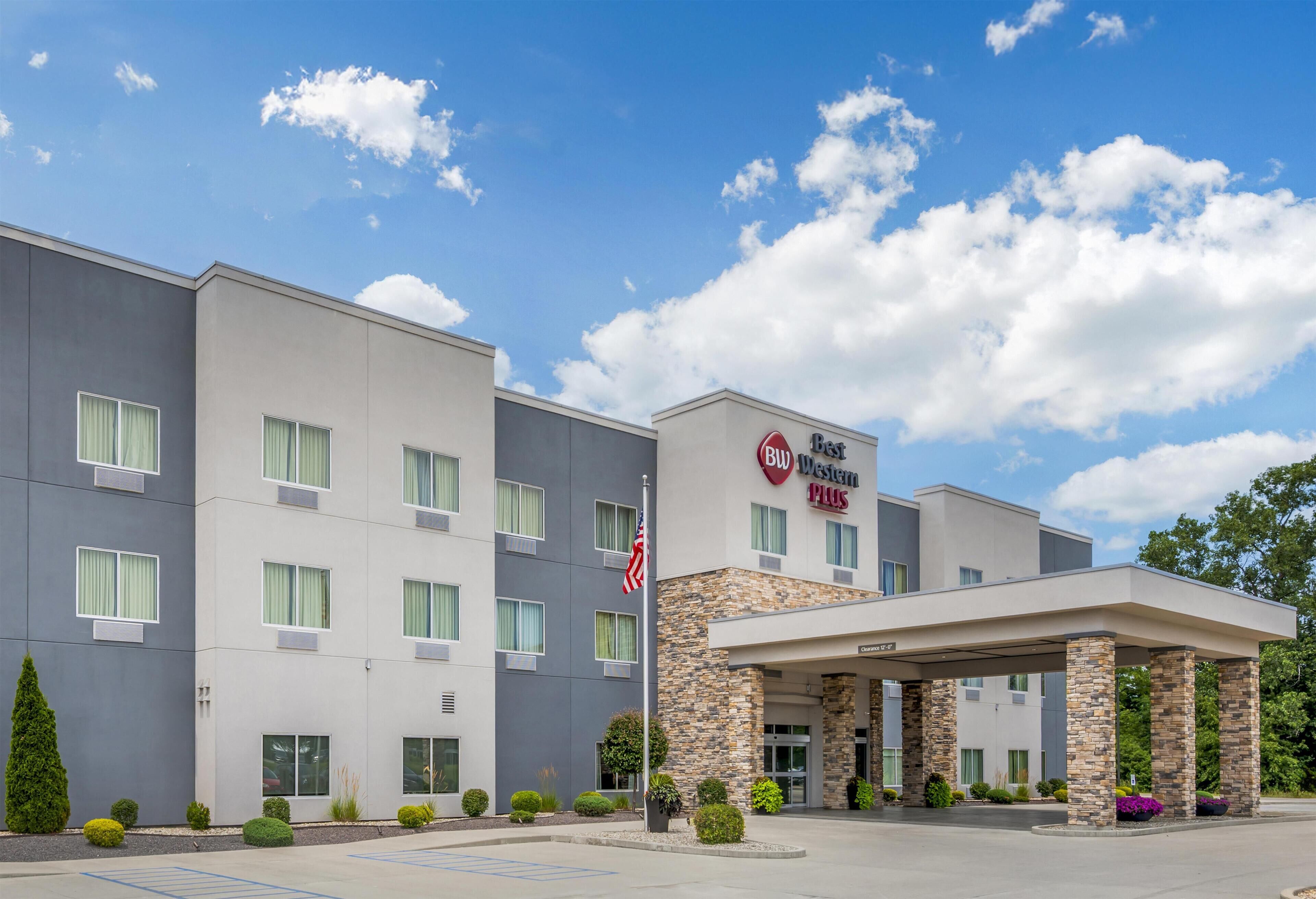 Hotel Bud Western Plaza, con diseño moderno, presenta una estructura de dos pisos, entrada cubierta y estacionamiento.