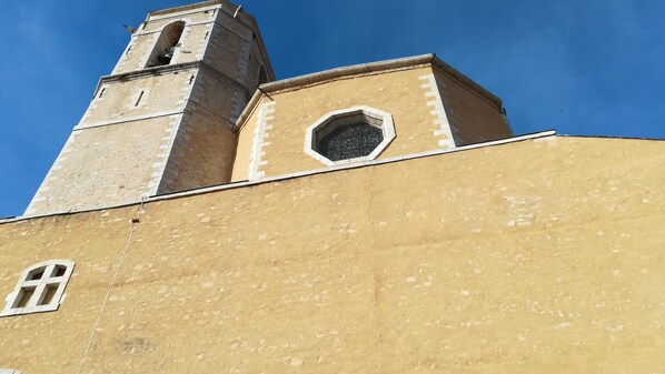 Una iglesia con un campanario y una ventana hexagonal.