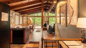 A spacious kitchen with a dining area, a large wooden ceiling, and a view of the outdoors. - Chalet in the Trees - Sauna|Game Room|Pool Access (Bellaire)