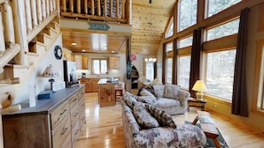 A cabin interior with a kitchen, dining area, and a living room with a sofa and a lamp. - Lakefront Hideaway (Litchfield)