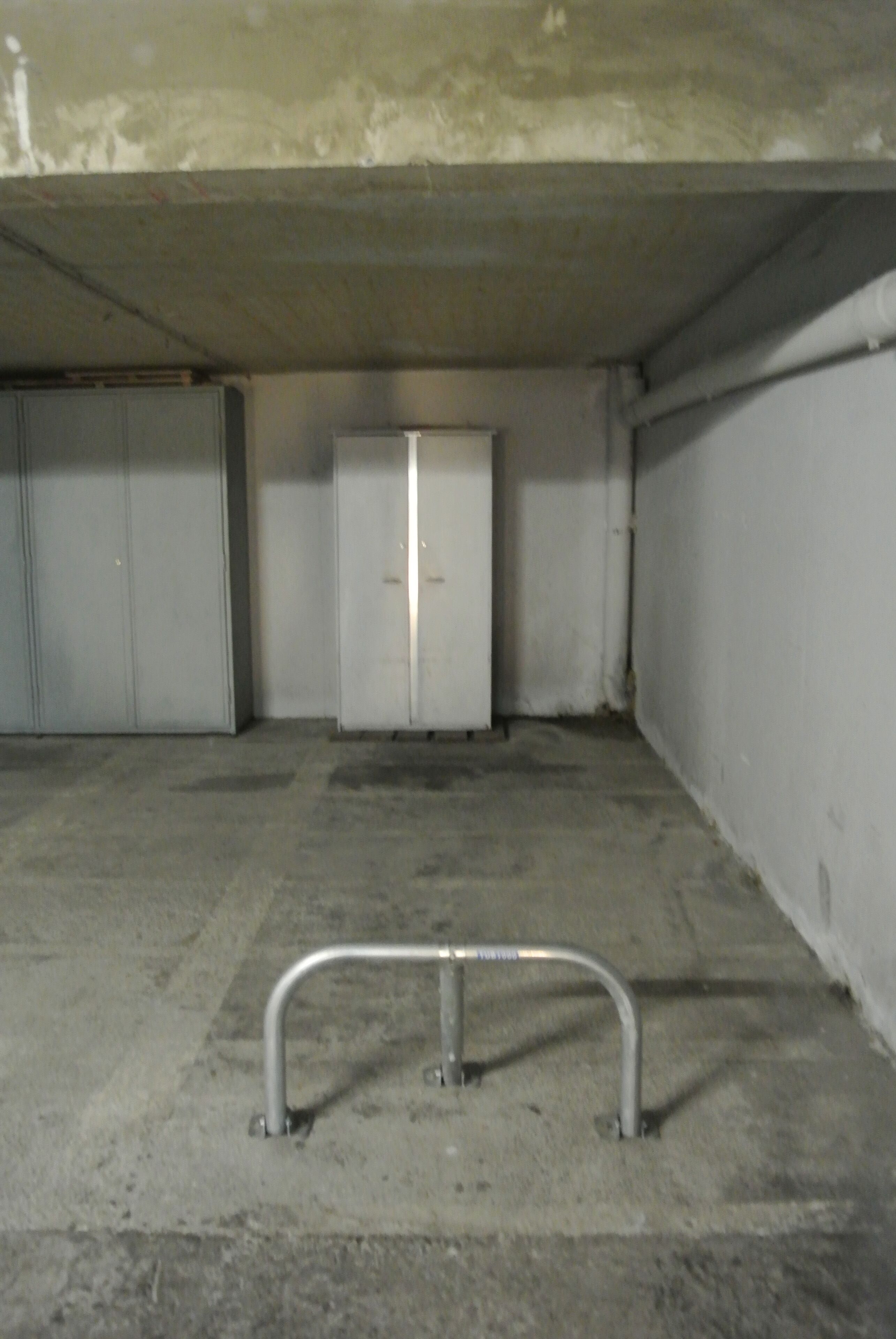 Eine Parkgarage mit Betonböden, Metallgeländern und weißen Türen.