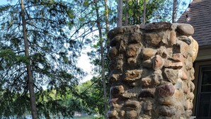 A stone structure with a staircase leading up to a deck. - Beachfront 1-bedroom home, 15-min. drive to Traverse City.  Private and peaceful (Traverse City)