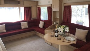 Ein gemütliches Wohnmobil-Interieur mit Essbereich, Sitzgelegenheiten und einer kleinen Küche.