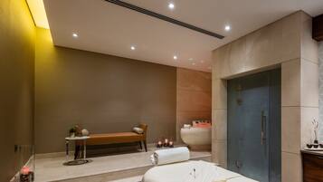Un spa moderno con una banca, una bañera y una camilla de masaje.