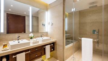 Un baño moderno con dos lavamanos, un espejo grande y una ducha con cerramiento de vidrio.