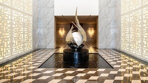 A lobby with a water feature, marble flooring, and patterned walls.