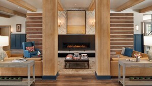 A modern living room with a fireplace, wooden beams, and a large abstract painting. - Cotton House, Cleveland, a Tribute Portfolio Hotel (Cleveland)
