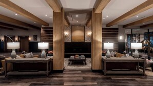 A spacious living area with a large fireplace, two sofas with side tables, and a coffee table. - Cotton House, Cleveland, a Tribute Portfolio Hotel (Cleveland)