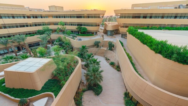 A modern building with curved architecture, multiple levels, and landscaped courtyards with palm trees and planters. - Riyadh Diplomatic Quarter - Marriott Executive Apartments (Riyadh)