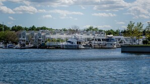 A marina with several boats docked, a row of houses with balconies, and a clear sky. - Owls Nest Beach House - Just Steps From Our Private Beautiful Sandy Beach (Union Pier)