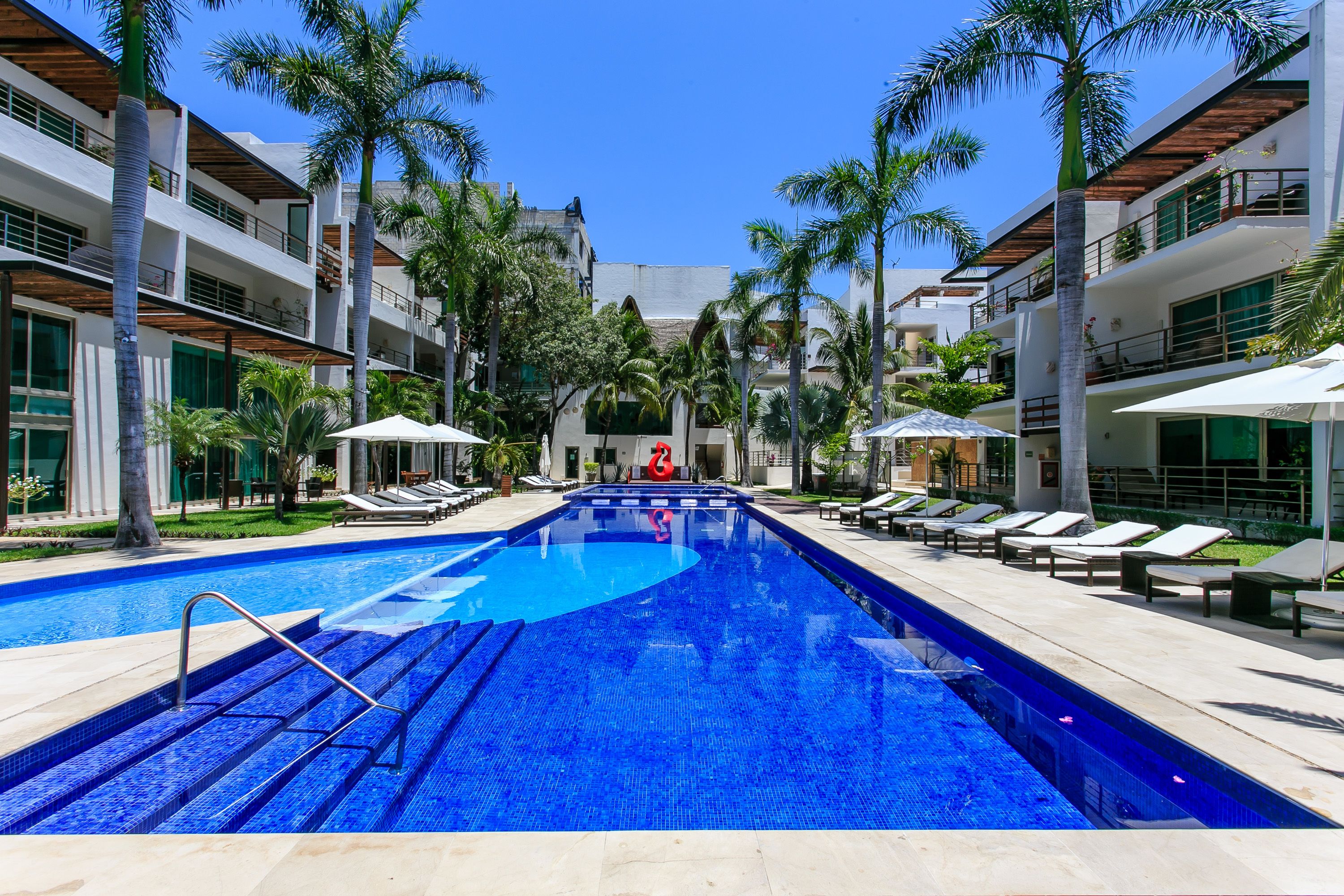 Alberca al aire libre, sombrillas en la alberca y camastros 