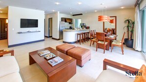 Una sala de estar moderna con televisor, mesa de centro y zona de estar.