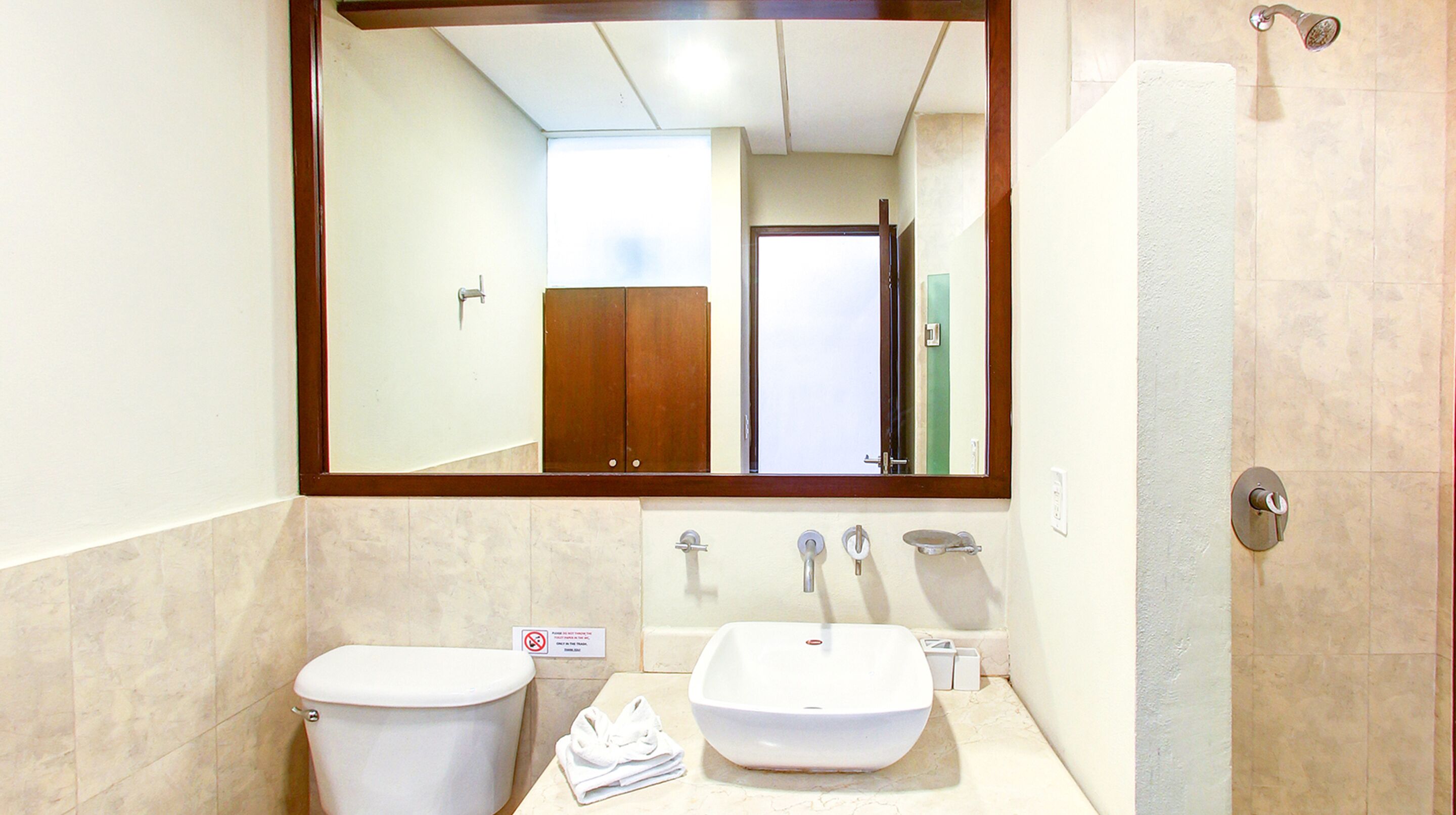 Un bagno con il water, un lavandino e uno specchio.