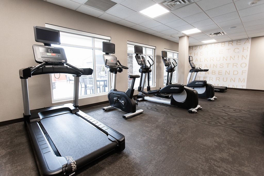 A gym with treadmills, elliptical machines, and a stationary bike.