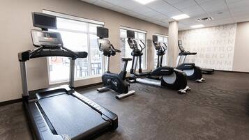 A gym with treadmills, elliptical machines, and a stationary bike.