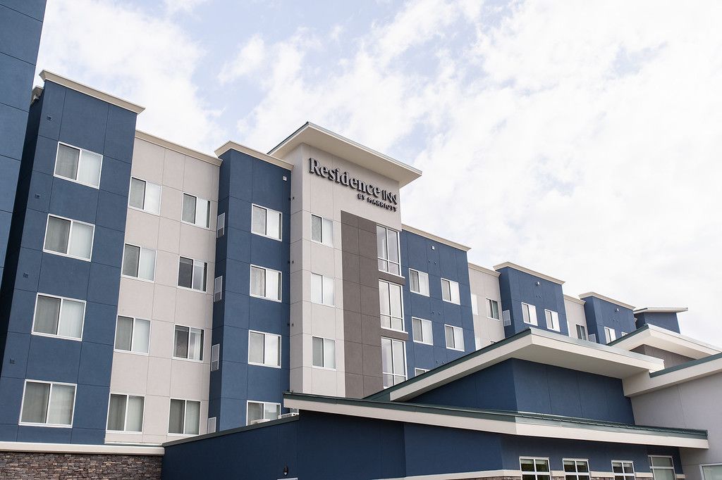 Un edificio de hotel de varios pisos con un diseño moderno, que presenta un letrero destacado de 'Residence Inn'.