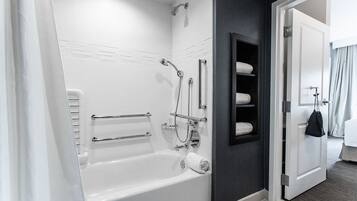 Un baño moderno con bañera, ducha y barra para toallas.