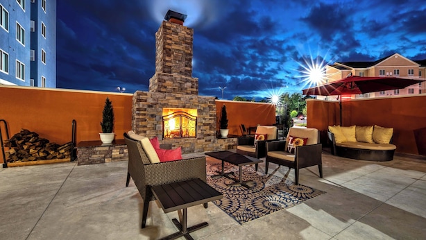 An outdoor patio with stone fireplace, seating, and a view of the night sky. - Residence Inn by Marriott Tulsa Midtown (Tulsa)