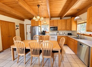 A kitchen with wooden cabinets, a stainless steel refrigerator, a microwave, and a dishwasher.