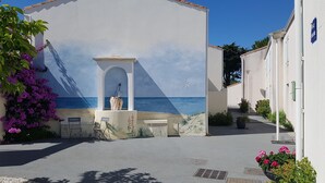 A narrow street with a building featuring a mural of the sea. - Vacation atmosphere - House - Swimming pool - Île de Ré (La Flotte en Ré)
