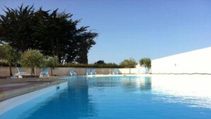 A clear swimming pool with lounge chairs and trees in the background. - Vacation atmosphere - House - Swimming pool - Île de Ré (La Flotte en Ré)