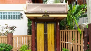 A villa entrance with a wooden gate, a sign above the door, and a tiled pathway leading to the entrance. - Villa Siam Lanna, private pool near the beach with sea view (koh lanta)