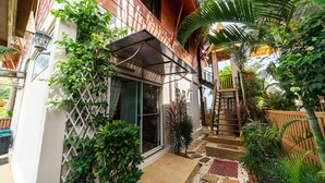 A covered outdoor area with a wooden staircase, a white lattice fence, and various plants. - Villa Siam Lanna, private pool near the beach with sea view (koh lanta)