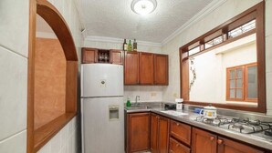 Uma cozinha compacta com geladeira, pia e fogão.