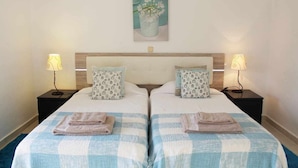 A double room with two beds, each with a pillow and a bedside table with a lamp. - 2 Bedroom Apartment with Swimming Pool at São Rafael Beach - Albufeira (Albufeira)