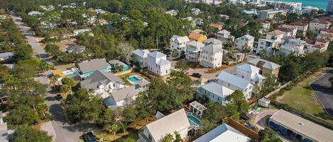 A residential area with houses, a swimming pool, and a view of the ocean.