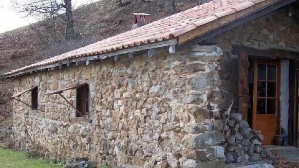 A rustic stone building with a tiled roof, a wooden door, and a small window. - Stylish, Basque sheepfold, all comfort (Pyrénées-Atlantiques)