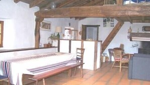 A rustic dining area with a wooden table, benches, and a high ceiling with exposed beams. - Stylish, Basque sheepfold, all comfort (Pyrénées-Atlantiques)