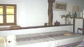 A room with a bed, a window, a shelf with items, and a painting on the wall. - Stylish, Basque sheepfold, all comfort (Pyrénées-Atlantiques)