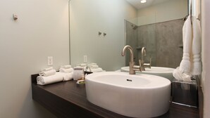 Un baño moderno con dos lavamanos, un espejo grande y toallas ordenadas en el mostrador.