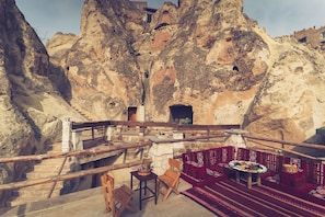 Experience the serene mountain retreat at this rustic inn, where a stone staircase leads to a charming deck with simple seating.