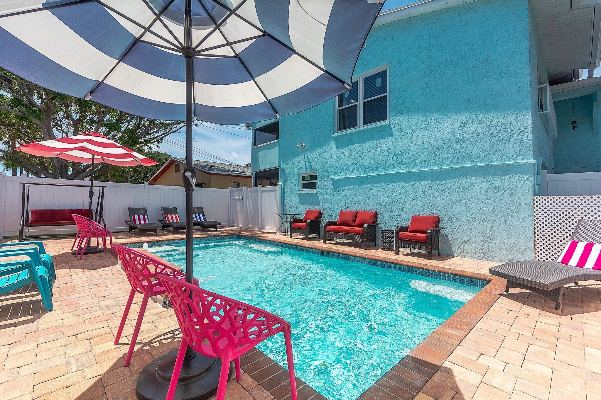 A swimming pool with lounge chairs and umbrellas.