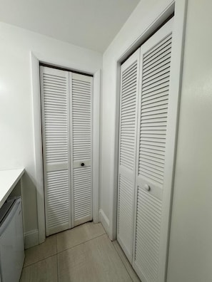 Un couloir avec une porte blanche et un mur blanc.
