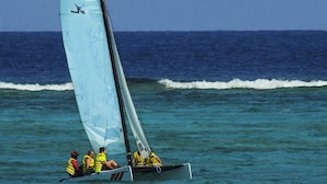A sailboat with multiple passengers wearing life jackets on a calm sea. - Grace Bay Beach Ocean Villas, Oleander Villa. Rated #1 On Trip Advisor. (Providenciales)