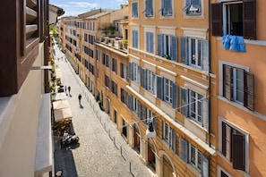 A cobblestone street lined with multi-story buildings, some with balconies and shutters. - Two Bedroom Apartment (Roma)