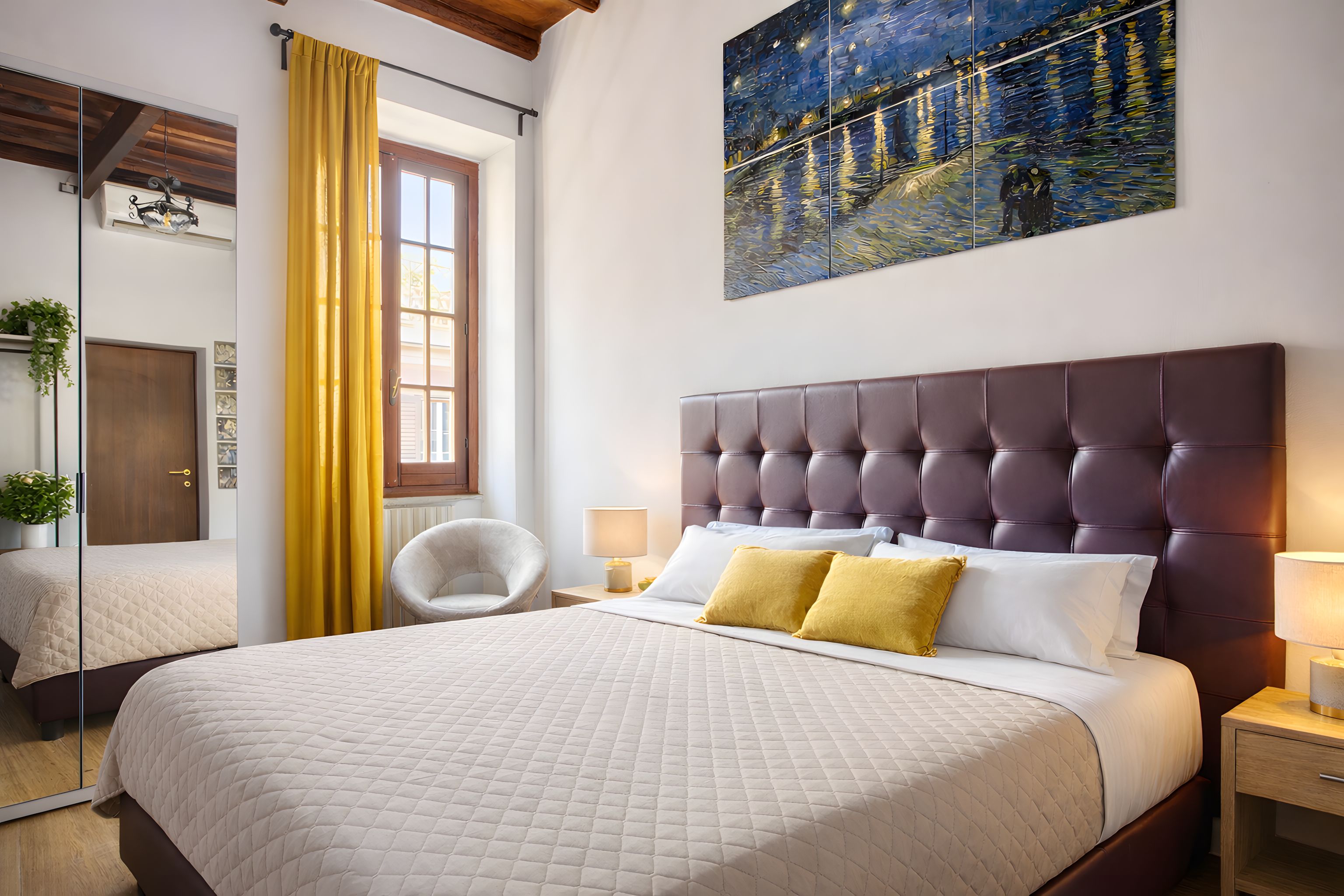 Une chambre à coucher avec un grand lit, une tête de lit, une table de chevet, une chaise et un tableau accroché au mur.
