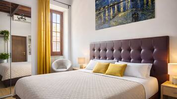 Une chambre à coucher avec un grand lit, une tête de lit, une table de chevet, une chaise et un tableau accroché au mur.