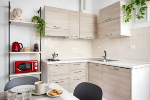 A modern kitchen with light wood cabinetry, a built-in microwave, a coffee maker, and a sink. - URBANA 37 MAISON   RIONE MONTI. (Roma)