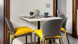 A dining area with a table, chairs, and a wall art piece. - URBANA 37 MAISON   RIONE MONTI. (Roma)