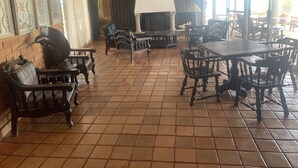 Un comedor amplio con mobiliario de madera y piso de baldosas.