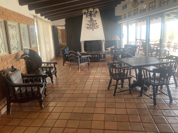 Un comedor amplio con mobiliario de madera y piso de baldosas.