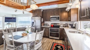 A modern kitchen with dark wood cabinets, stainless steel appliances, and a white countertop. - 14 Captain Crocker (East Sandwich)