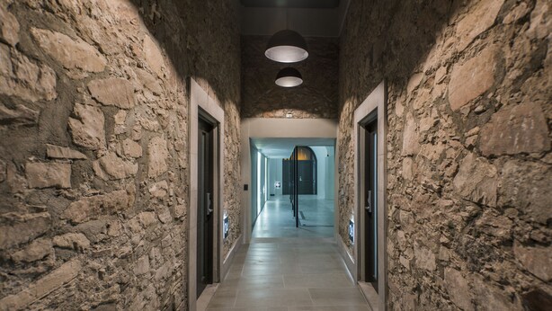A corridor with stone walls, a tiled floor, and a ceiling light fixture. - La Casona que Encanta (Querétaro)