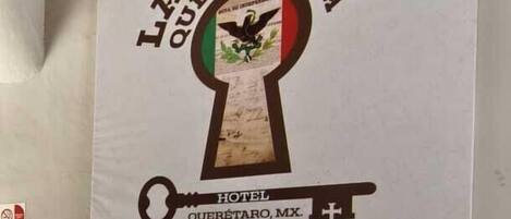 A hotel sign with a keyhole logo and the name 'LA CASONA QUE ENCANTA' indicating a welcoming atmosphere.
